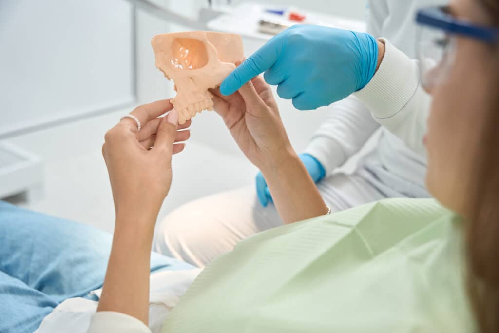 Dentista explicando a un paciente un injerto de hueso y regeneración ósea