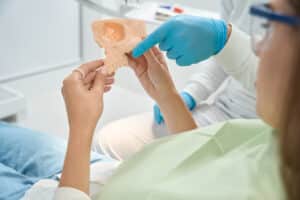 Dentista explicando a un paciente un injerto de hueso y regeneración ósea